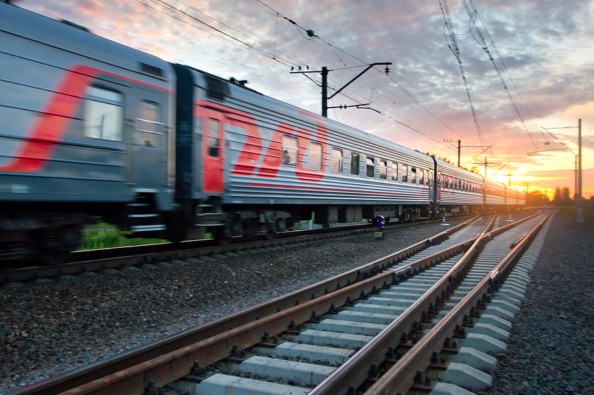 Пассажирский скорый поезд мчится на закате © Александр Тарасенков / Фотобанк Лори